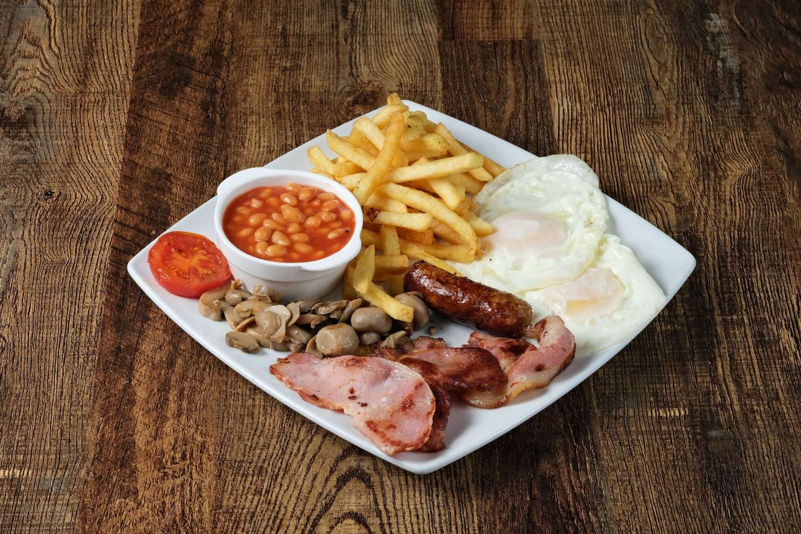A full English breakfast with bacon, sausage, eggs, mushrooms, beans and chips